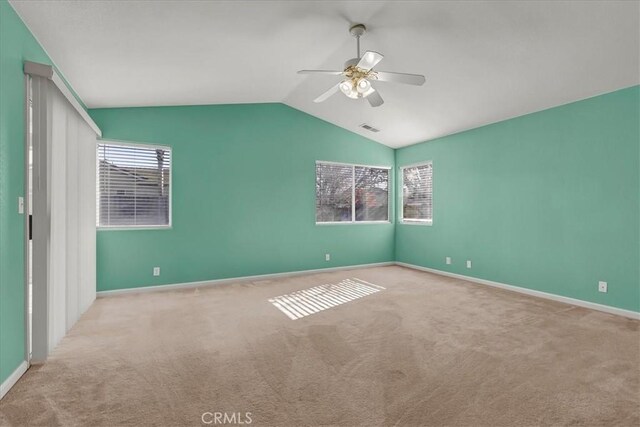 carpeted spare room with lofted ceiling and ceiling fan