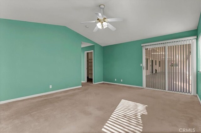 interior space featuring ceiling fan, light carpet, and lofted ceiling