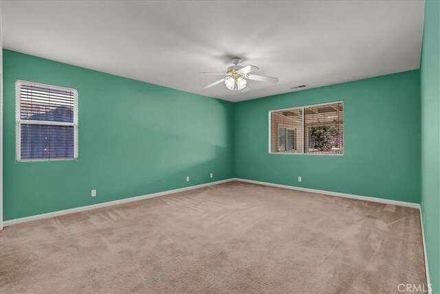 unfurnished room with light carpet and ceiling fan