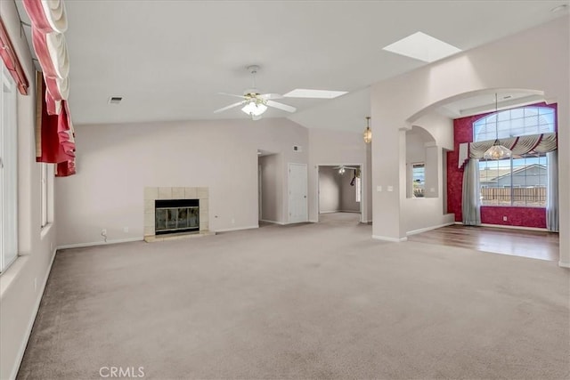 unfurnished living room featuring ceiling fan, carpet, a fireplace, and lofted ceiling