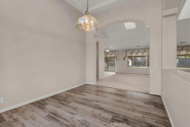 unfurnished dining area with an inviting chandelier and hardwood / wood-style floors