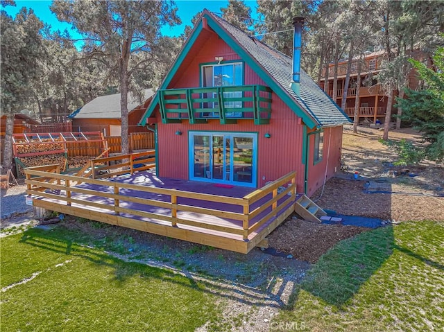 back of property featuring a balcony and a wooden deck