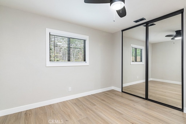 unfurnished bedroom featuring ceiling fan, light wood-type flooring, and a closet