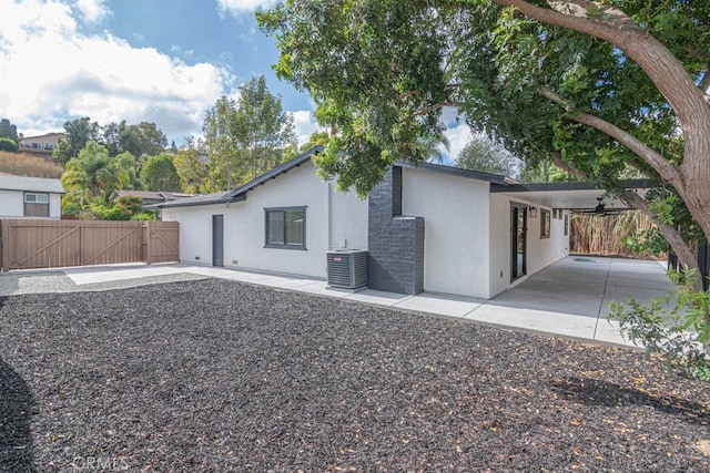 rear view of house featuring a carport and central AC