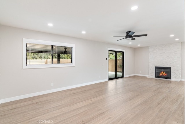 unfurnished living room with a fireplace, light hardwood / wood-style flooring, and ceiling fan