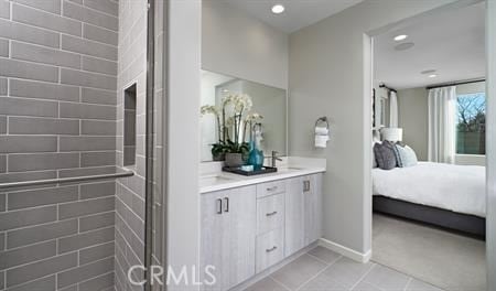 bathroom featuring tile patterned flooring, vanity, and a shower with shower door