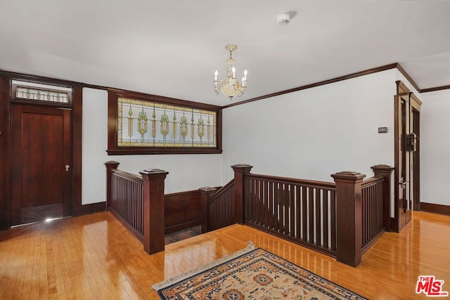 foyer featuring ornamental molding, a chandelier, and light hardwood / wood-style floors