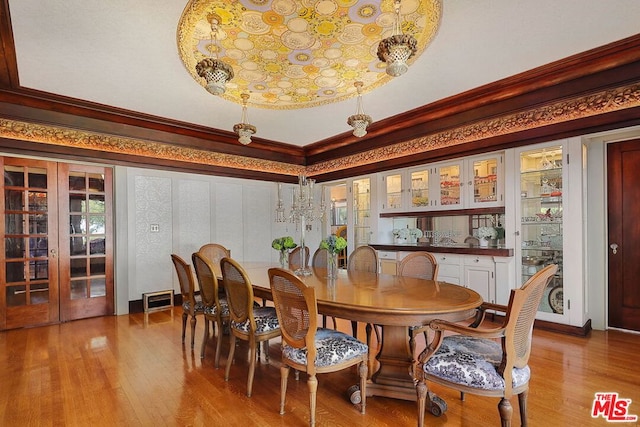 dining area with light wood-type flooring and crown molding