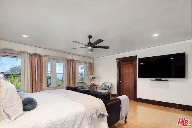 bedroom featuring light hardwood / wood-style flooring, ornamental molding, multiple windows, and ceiling fan