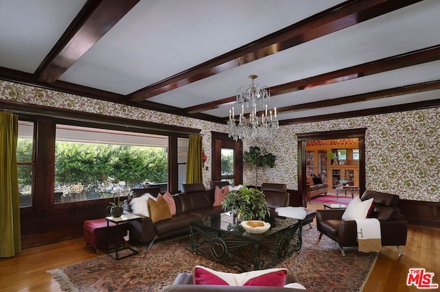 living room with light wood-type flooring, beam ceiling, and an inviting chandelier