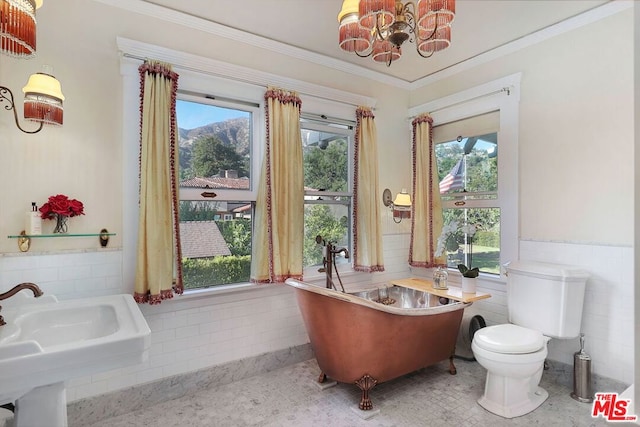 bathroom with a bathing tub, a chandelier, plenty of natural light, and toilet