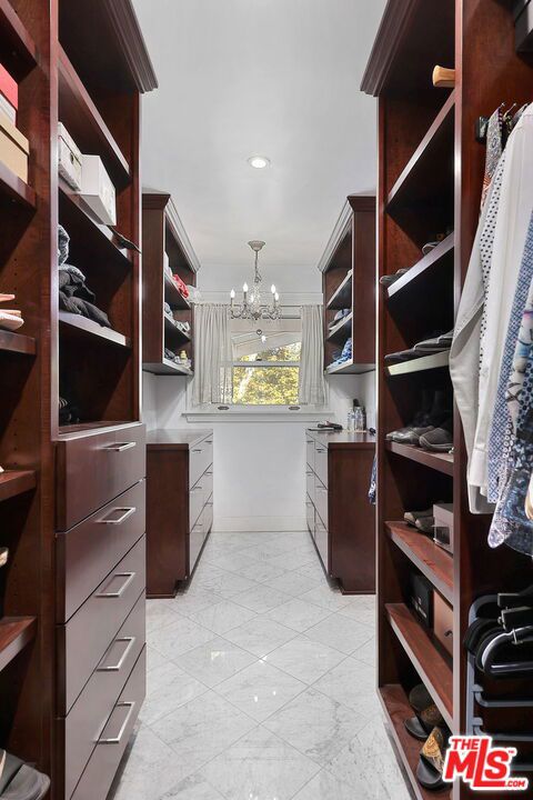 spacious closet with a notable chandelier