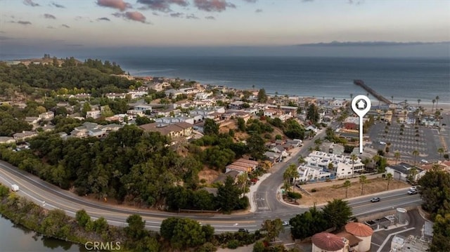 aerial view at dusk featuring a water view