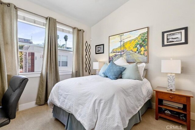 carpeted bedroom with lofted ceiling