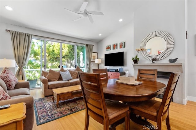 dining area with light hardwood / wood-style floors, ceiling fan, and vaulted ceiling