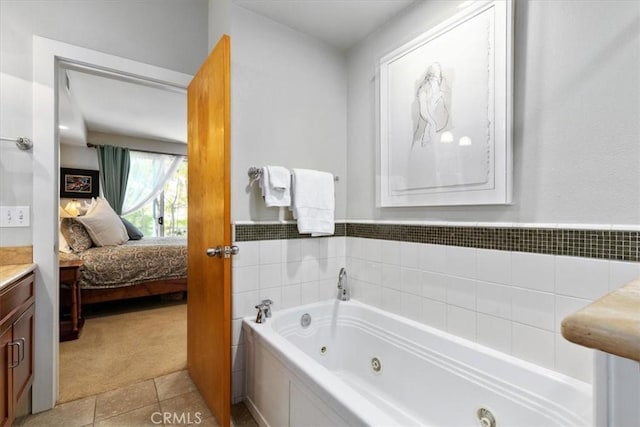 full bath featuring a whirlpool tub, tile patterned floors, connected bathroom, and vanity