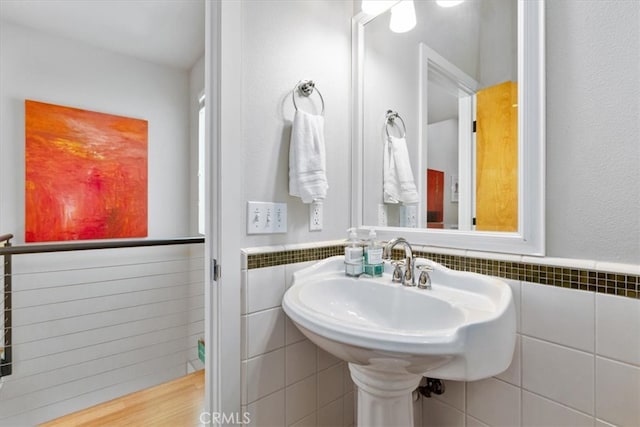 bathroom featuring hardwood / wood-style flooring and tile walls