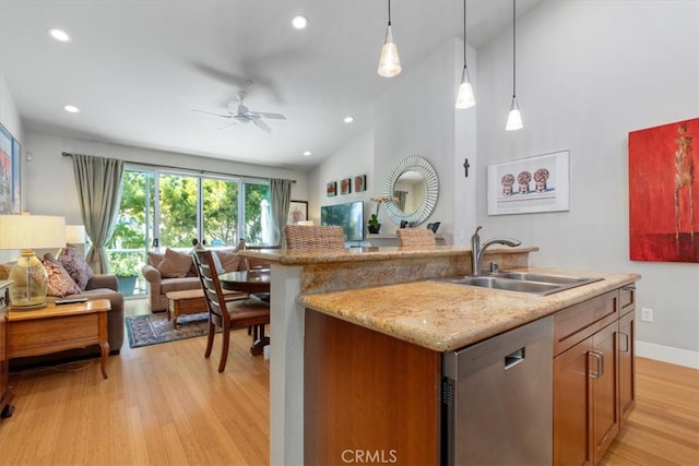 kitchen with a kitchen island with sink, light hardwood / wood-style flooring, dishwasher, pendant lighting, and sink