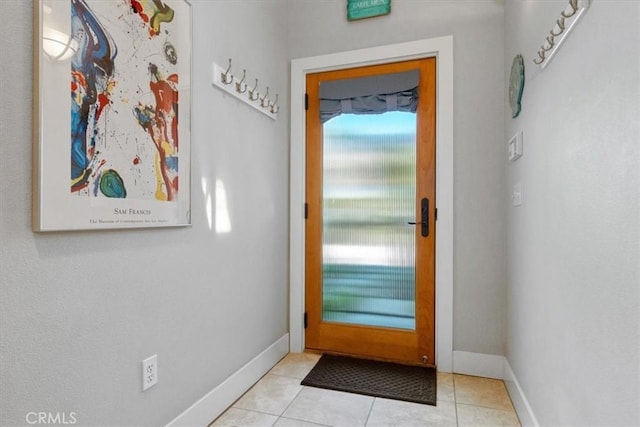 entryway with baseboards and light tile patterned floors