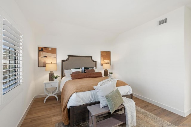 bedroom with lofted ceiling and hardwood / wood-style floors