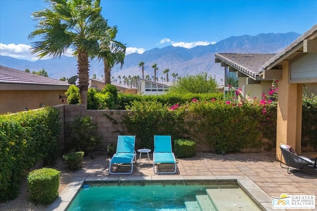 view of pool with a mountain view and a patio area