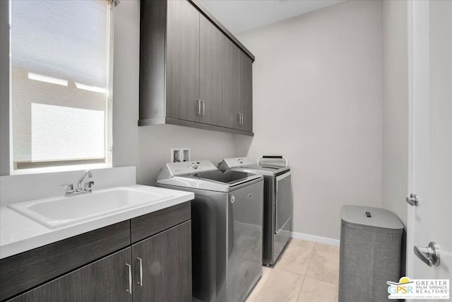 washroom featuring light tile patterned flooring, cabinets, separate washer and dryer, and sink