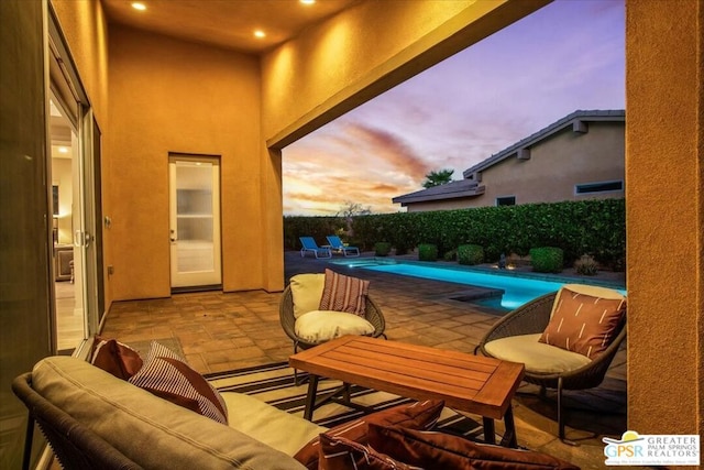 patio terrace at dusk with a fenced in pool