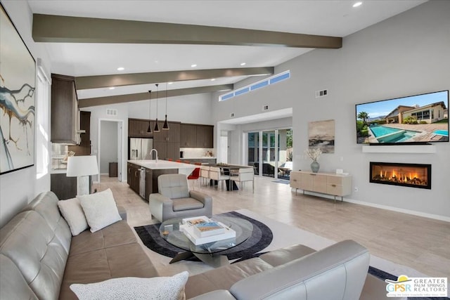 living room with beam ceiling and high vaulted ceiling