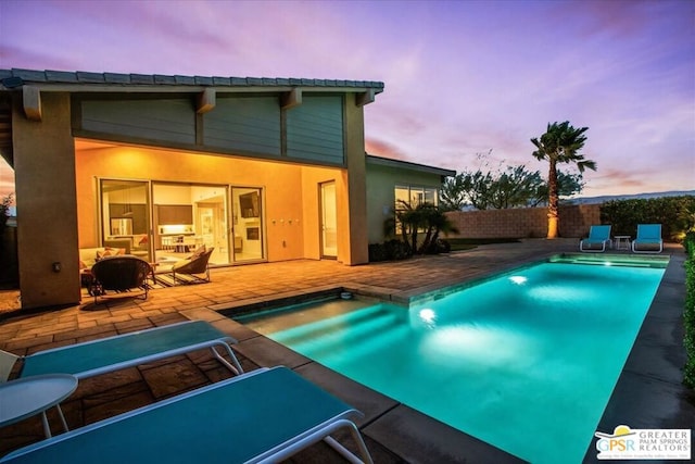 pool at dusk with a patio