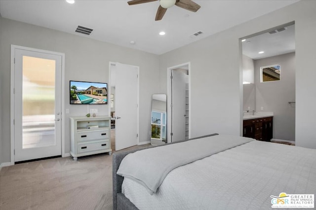 bedroom with ceiling fan, light carpet, and ensuite bath