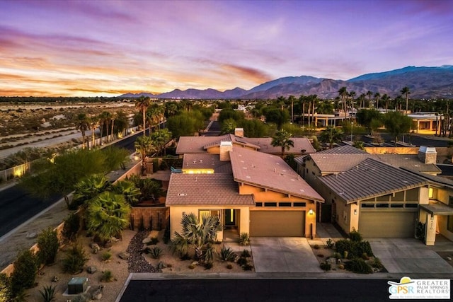 aerial view at dusk featuring a mountain view