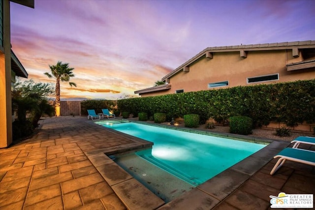 pool at dusk with a patio