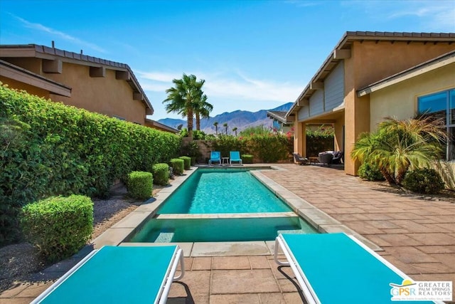 view of pool with a mountain view and a patio