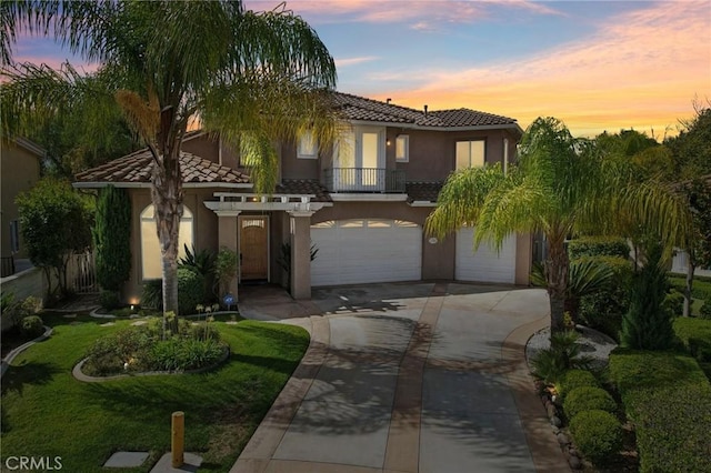 mediterranean / spanish-style house featuring a garage and a yard