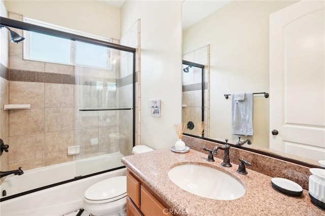 full bathroom featuring shower / bath combination with glass door, vanity, and toilet