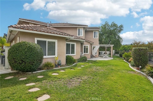 rear view of property with a pergola, a patio, and a lawn