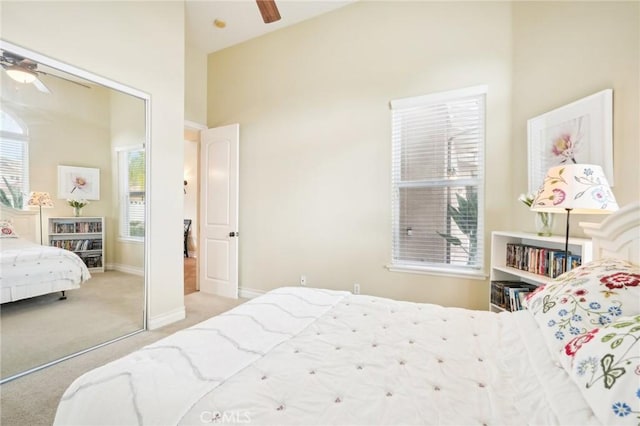 carpeted bedroom featuring multiple windows, ceiling fan, a closet, and high vaulted ceiling