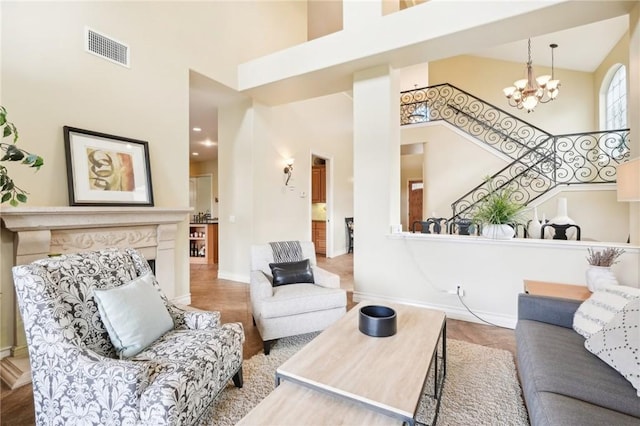 living room featuring hardwood / wood-style floors, a towering ceiling, and an inviting chandelier