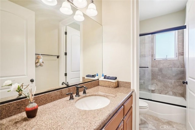 full bathroom with shower / bath combination with glass door, tile patterned floors, vanity, and toilet