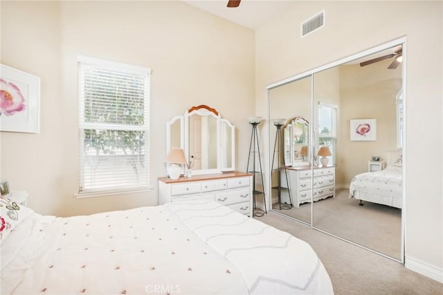 carpeted bedroom with ceiling fan and a closet