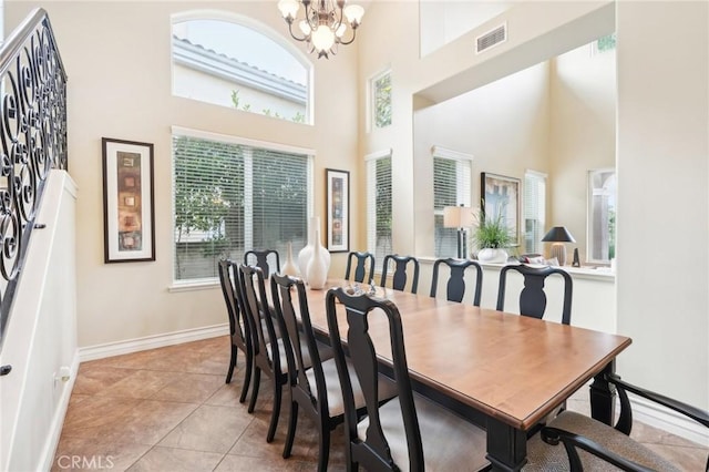 tiled dining room with a high ceiling and an inviting chandelier