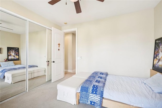 carpeted bedroom featuring ceiling fan and a closet