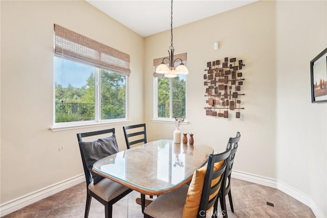 dining area with tile patterned floors and a notable chandelier