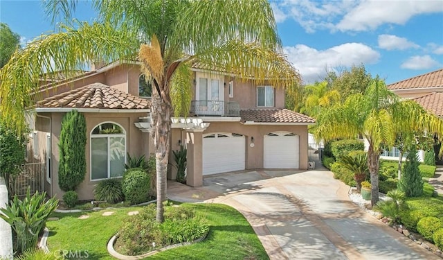 mediterranean / spanish home featuring a front yard and a garage