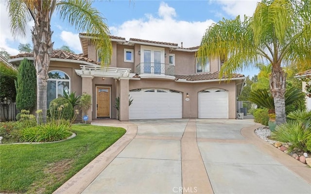 mediterranean / spanish-style home featuring a balcony, a front lawn, and a garage