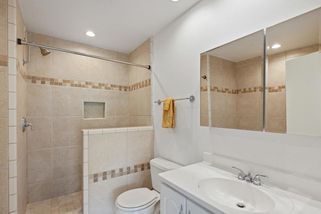 bathroom featuring vanity, toilet, and a tile shower