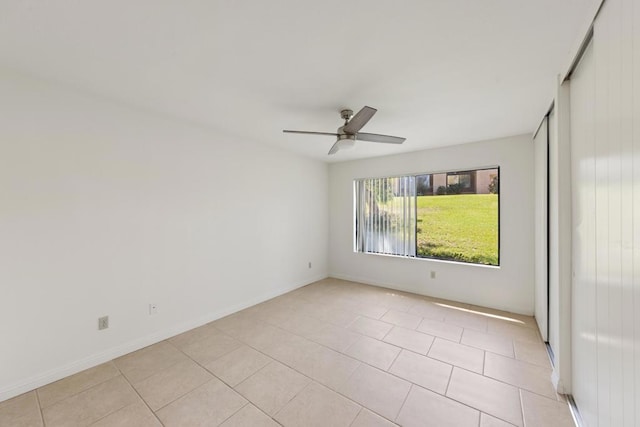 tiled spare room featuring ceiling fan