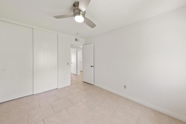 unfurnished bedroom featuring ceiling fan, light tile patterned flooring, and a closet