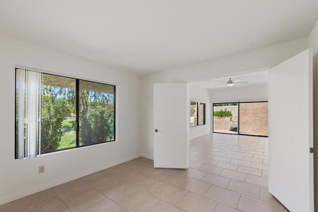 tiled spare room featuring ceiling fan