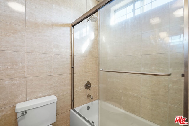 bathroom featuring bath / shower combo with glass door and toilet